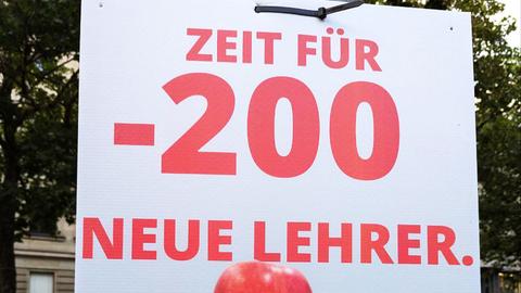Plakat mit Büchern und einem roten Apfel, davor das Logo der SPD und Schrift in roter Farbe: "Zeit für -200 neue Lehrer"