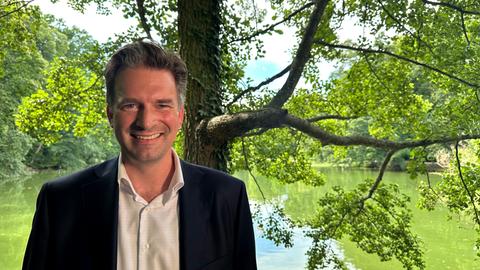 Oberbürgermeister Schoeller steht vor dem Lac, einem See am Schloss Wilhelmshöhe