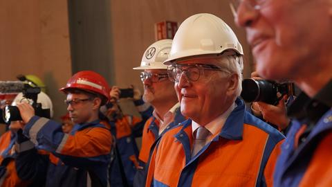 Steinmeier mit weißem Helm und blau-organgefarbener Schutzkleidung