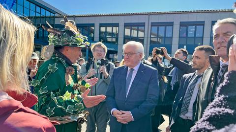 Bundespräsident Frank-Walter Steinmeier (r.) im Gespräch mit einem als "Wald" verkleideten Mann - umringt von anderen Menschen