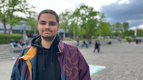 Schüler schaut in die Kamera, im Hintergrund der Schulhof.