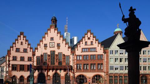 Rathaus Römer in Frankfurt, ein Haus mit drei Gebäudeteilen mit Zinnen, im Vordergrund ein Brunnen im Schatten