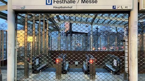 Der Eingang zu einer U-Bahn-Station "Frankfurt Messe/Festhalle" ist zwar beleuchtet, aber mit einem Gitter verschlossen.