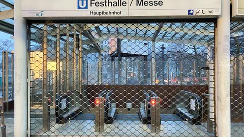 Der Eingang zu einer U-Bahn-Station "Frankfurt Messe/Festhalle" ist zwar beleuchtet, aber mit einem Gitter verschlossen.