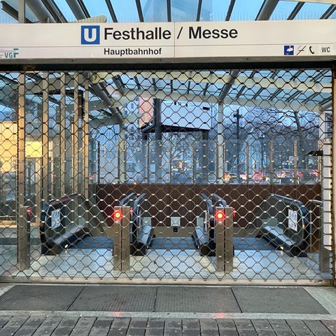 Der Eingang zu einer U-Bahn-Station "Frankfurt Messe/Festhalle" ist zwar beleuchtet, aber mit einem Gitter verschlossen.