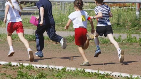 Kinder rennen über eine Laufbahn