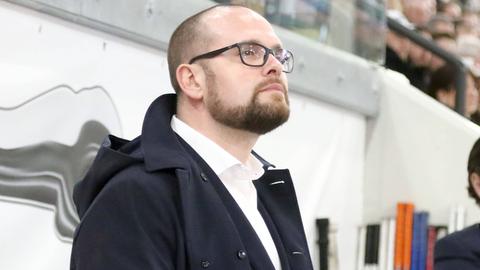 Löwen-Sportdirektor Daniel Heinrizi mit Mantel. Blickt hoch.