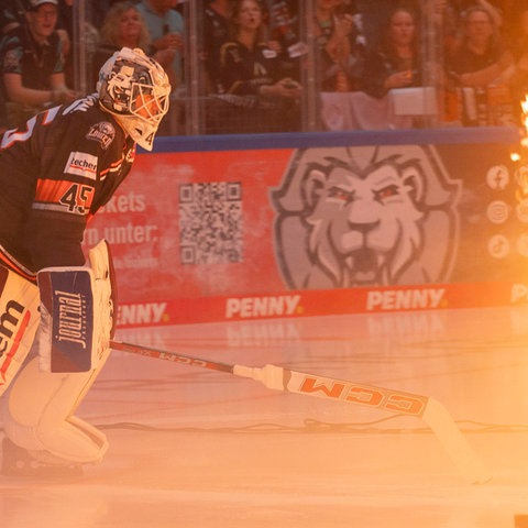 Löwen-Goalie Jussi Olkinuora kommt aufs Eis. Neben ihm Pyrotechnik mit Feuer.