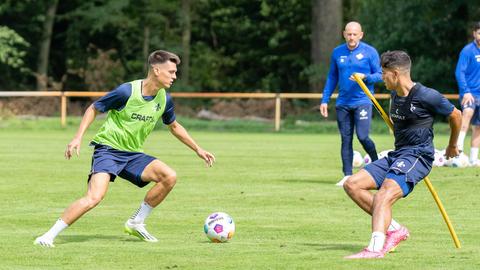 Das Bild zeigt Mathias Honsak im Zweikampf mit Fabio Torsiello, dahinter ist Trainer Torsten Lieberknecht zu sehen.