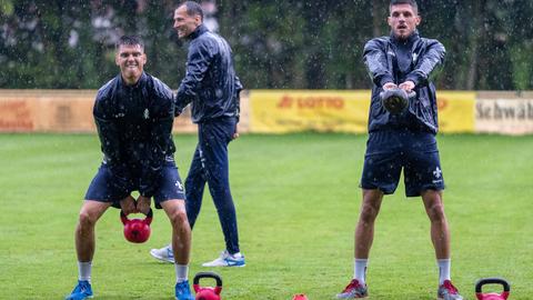 Die SVD-Spieler Honsak und Karic trainieren im Regen mit Gewichten.