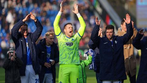 Die Lilien-Spieler feiern nach dem Sieg gegen Hertha mit den Fans.