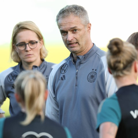 Bundestrainer Christian Wück bei der Ansprache im Training. Vor ihm verschiedene Spielerinnen.