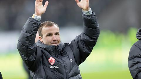 Mario Götze gestikuliert in Winterjacke in Richtung Fans