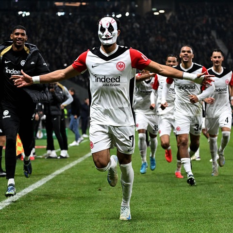 Omar Marmoush bejubelt sein Tor für die Eintracht mit Maske vor dem Gesicht