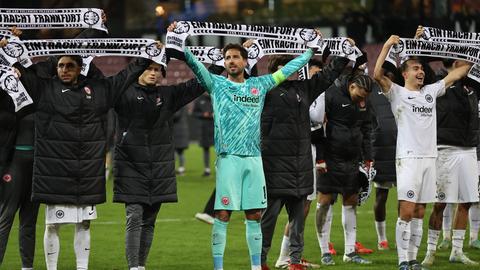 SGE-Spieler um Kevin Trapp (M) feiern nach dem Sieg in Midtjylland mit den Fans