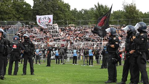 Polizisten stehen in Leipzig auf dem Rasen vor dem Fanblock von Eintracht Frankfurt