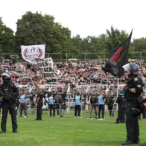 Polizisten stehen in Leipzig auf dem Rasen vor dem Fanblock von Eintracht Frankfurt