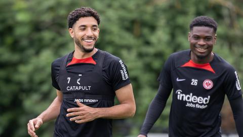 Omar Marmoush und Eric-Junior Dina Ebimbe im Trainingsshirt von Eintracht Frankfurt.