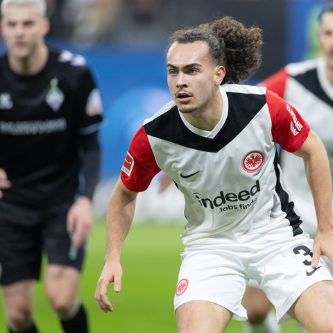 Eintracht-Abwehrspieler Arthur Theate blickt konzrentriert auf den Ball.