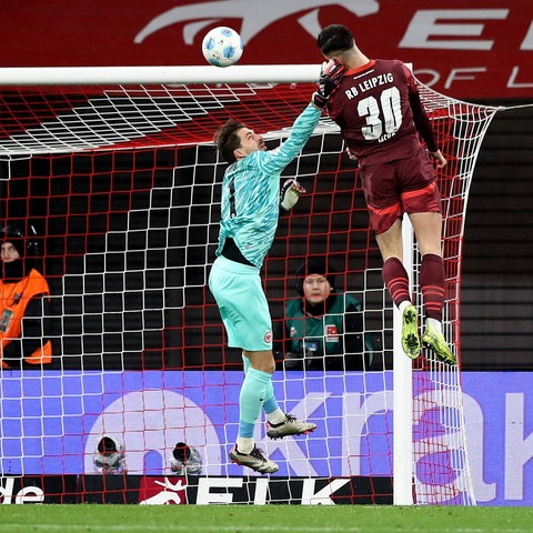 Eintracht-Keeper Kevin Trapp beim Abwehrversuch gegen Leipzigs Sesko.