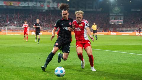 Eintracht Frankfurts Arthur Theate im Duell mit Benedict Hollerbach von Union Berlin