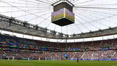 Foto eines voll besetzen Fußballstadions während eines Spiels.