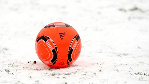 Ein roter Fußball im Schnee