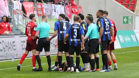 Spieler des FSV Frankfurt und der Offenbacher Kickers diskutieren mit dem Schiedsrichter. 