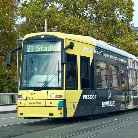 Eine fahrende Straßenbahn. An ihrer Stirn steht "21 Stadion".