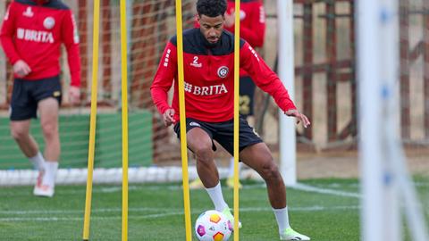 Martin Angha beim Training. Umkurvt mit dem Ball gelbe Stangen.