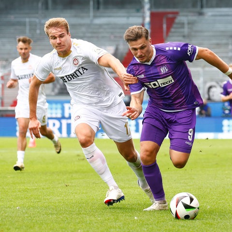 Florian Carstens vom SV Wehen Wiesbaden im Duell mit Erik Engelhardt von Osnabrück