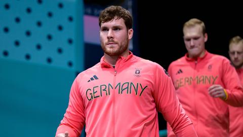 Handballer Johannes Golla läuft ein. Bei Olympia mit roter Jacke.