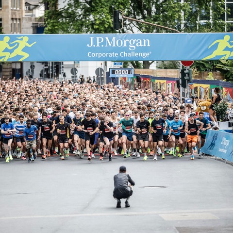 Ein Fotograf kniet vor dem Startfeld beim JP Morgan-Firmenlauf in der Frankfurter Innenstadt am 5. Juni 2024