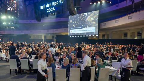 Die Gäste des Ball des Sports sitzen in der Frankfurter Festhalle während des Essens an den Tischen.