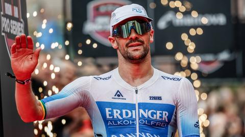 Patrick Lange winkt den Fans beim Zieleinlauf in Frankfurt zu