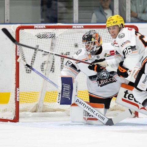 Zwei Eishockeyspieler rangeln vor dem Tor auf dem Spielfeld.