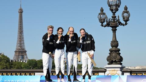 Traithletin Lisa Tertsch beißt mit ihren Mannschaftskollegen in die Goldmedaille