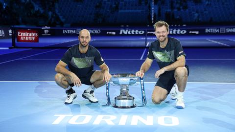 Tim Pütz und Kevin Krawietz hocken neben dem Pokal der ATP-Finals