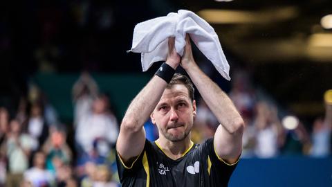 Tischtennisspieler Timo Boll. Mit Tränen in den Augen. Hebt das Handtuch über den Kopf.