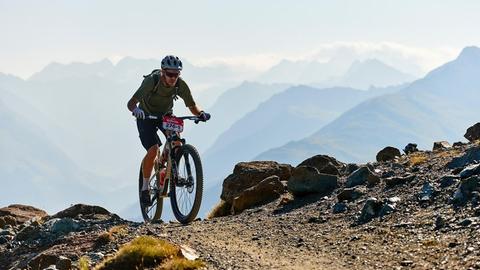 Sebastian Vettel fährt beim Epic Swiss Mountainbike Rennen auf eine Bergspitze.