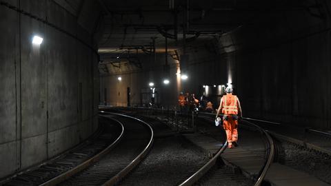 Ein dunkler Tunnel, Männer in orangenen Arbeitsanzügen