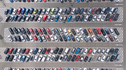 Viele Autos stehen auf einem Parkplatz (Luftaufnahme).