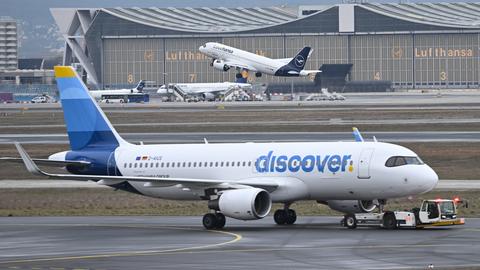 Ein Passagierflugzeug der Discover Airlines wird am Frankfurter Flughafen von einem Schlepper gezogen.