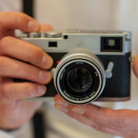 Zwei Hände halten eine Leica-Kamera. Es handelt sich um das Spitzen-Modell, eine Leica M1 1-P.