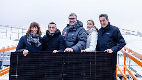 Diana Rauhut, Mike Josef, Axel Hellmann, Tina Zapf-Rodriguez, Dr. Michael Maxelon stehen in dicken Jacken nebeneinander auf einem Dach und posieren für die Kamera. 