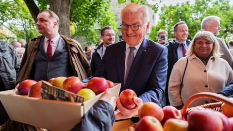 Frank-Walter Steinmeier, Bundespräsident, nimmt auf dem Erntedankfest einen Korb Äpfel entgegen.