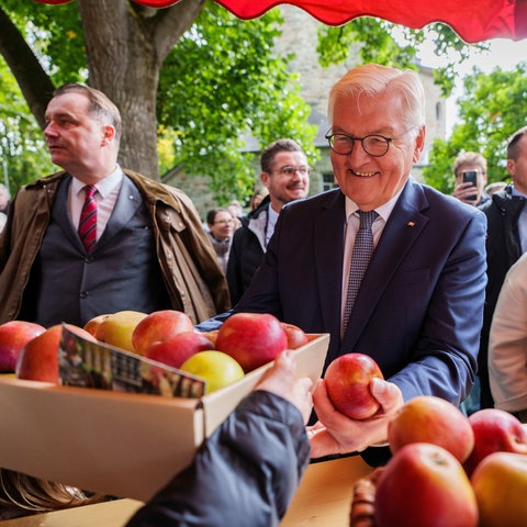 Frank-Walter Steinmeier, Bundespräsident, nimmt auf dem Erntedankfest einen Korb Äpfel entgegen.