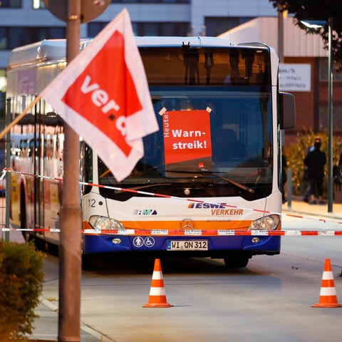 Stadtbus in Wiesbaden steht, darauf rotes Schild mit Schriftzug "Wir streiken"