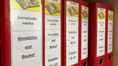 Viele rote Aktenordner, sie sind mit "Gemeindewerke" beschriftet.