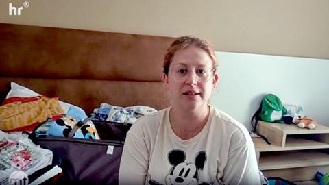 Eine deutsche Urlauberin in Ägypten mit Micky-Maus-T-Shirt sitzt in einem Hotelzimmer und blickt in die Kamera